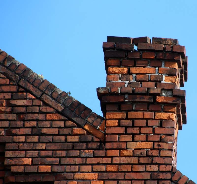 Damaged chimney on an Pembroke home showing cracks and missing mortar
